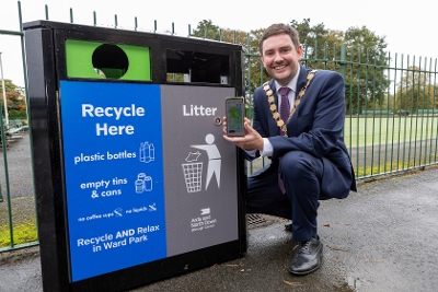 Mayor of Ards and North Down, Councillor Craig Blaney beside one of ten new dual-compartment recycling bins at key locations at Ward Park, as part of the new 'Recycling on the Go' Trial.